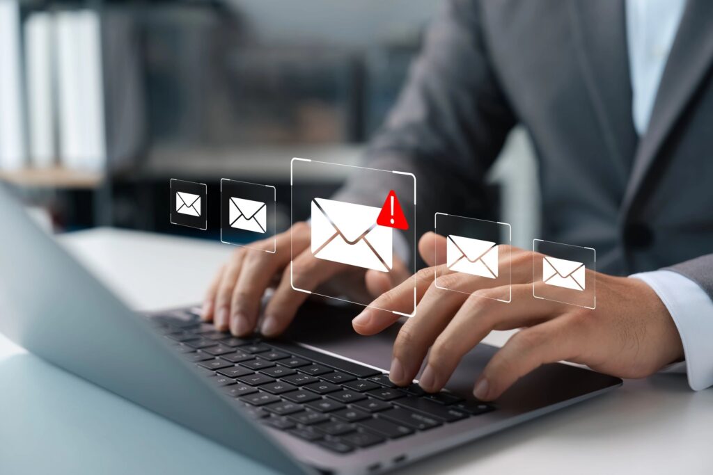 man typing on laptop with digital envelops on image
